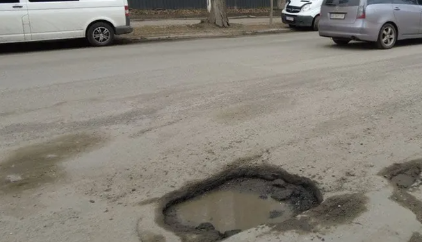 У Києві після дощів дорога покрилася величезними ямами: відео