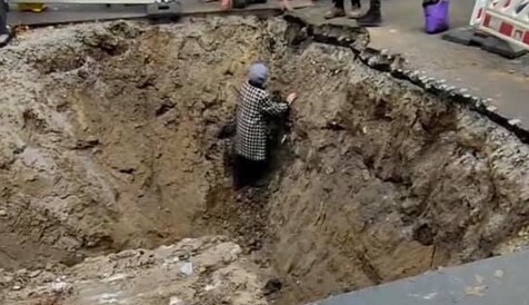 У Києві у вириту комунальниками яму впала бабуся: фото і відео порятунку