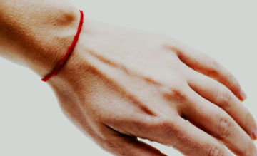 Красная "нить судьбы" на руке: реальное значение и история оберега